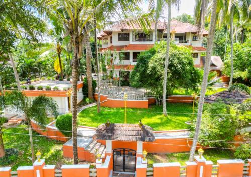 a house with palm trees in front of it at Ushasree Wayanad Pool Resort by VOYE HOMES in Ambalavayal