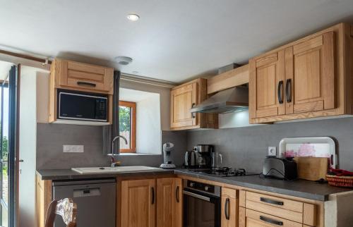 a kitchen with wooden cabinets and a stove top oven at Gite lilas in Le Pont-de-Montvert