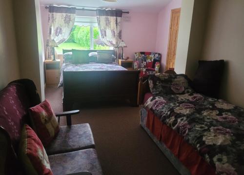 a bedroom with a bed and a couch and a window at The Railway Lodge - 4 Bedrooms Sleeps 11 Pets Ok in Moate