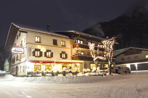 a large building with lights on in the snow at Landgasthof Kaiserkrone in Elmen