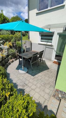 a table and chairs under an umbrella on a patio at Wunderschöne Wohnung mit Kamin in Starzach