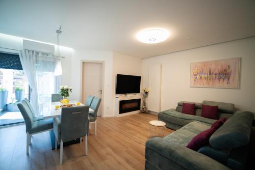 a living room with a couch and a table and a television at Apartman Tajči in Koprivnica