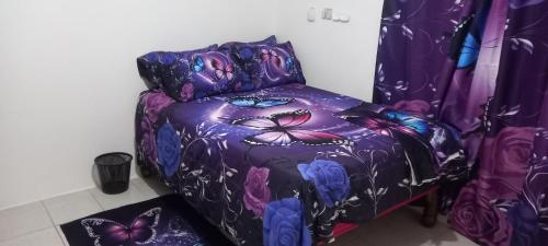 a bedroom with a purple bed with butterflies on it at Holiday rooms in St Thomas Jamaica in Clifton