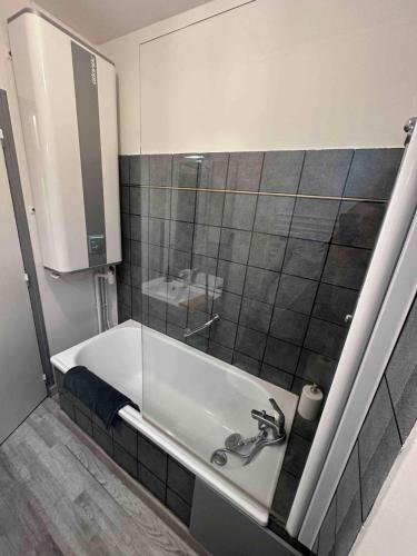 une salle de bain avec un lavabo et un miroir dans l'établissement L'Impérial, à Auxerre