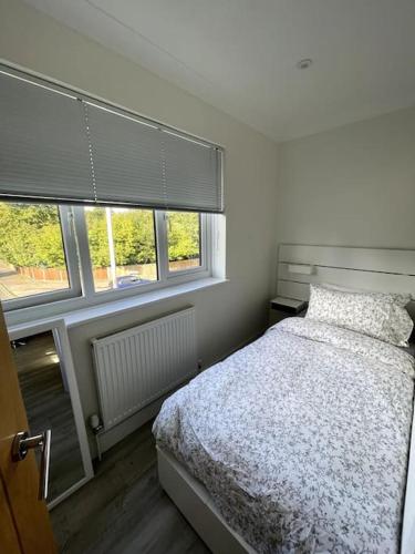 a bedroom with a bed and two windows at 2 Bedroom Flat Bracknell Free Parking in Bracknell