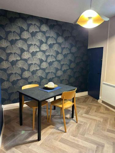 une salle à manger avec une table noire et deux chaises dans l'établissement L'Impérial, à Auxerre