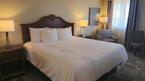 a hotel room with a large bed with white sheets at Best Western Plus Dubuque Hotel and Conference Center in Dubuque