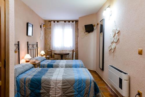 a hotel room with two beds and a window at La cañada real in Sigueruelo