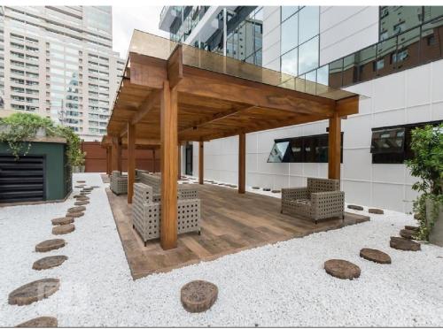 a wooden pavilion on the side of a building at Flat Novo1 - Cama Queen, Ar, Estac e Internet in Barueri