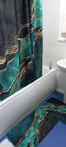 a bathroom with a bath tub with a shower curtain at Holiday rooms in St Thomas Jamaica in Clifton