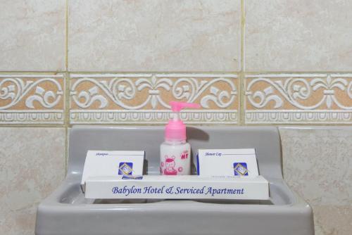 a bottle of soap and a soap dispenser on a sink at Babylon Hotel & Serviced Apartment in Dhaka