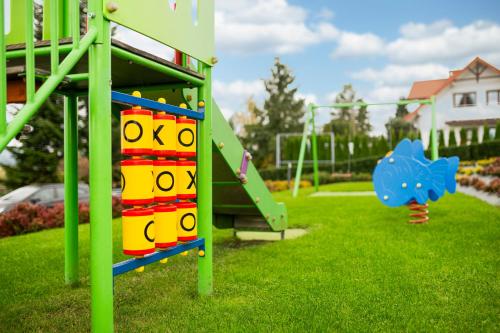 a playground with a slide in a park at Vela Polańczyk Rodzinne Domki Nad Jeziorem in Polańczyk