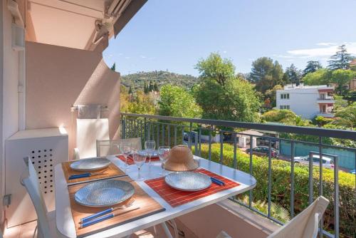 une table avec des assiettes et des verres sur un balcon dans l'établissement LE BELLA studio avec balcon idéal pour une évasion à deux, au calme et proche du centre-ville, à Cannes