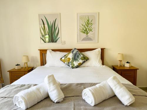 a bedroom with a white bed with two pillows at Royal-seacrest Oasis, Pool-side in Paphos City