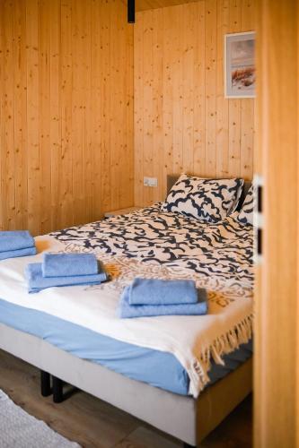 a bedroom with a bed with blue towels on it at Domki Morska Olivka in Puck