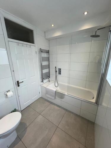 a white bathroom with a tub and a toilet at City Escape in London
