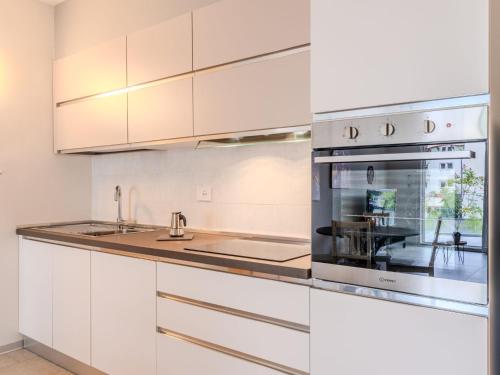 a kitchen with white cabinets and stainless steel appliances at Apartment Arianna by Interhome in Arco