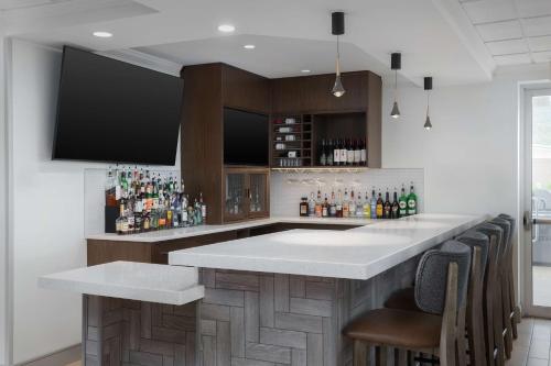 a bar with a white counter and some bottles at Hilton Garden Inn Wilkes-Barre in Wilkes-Barre