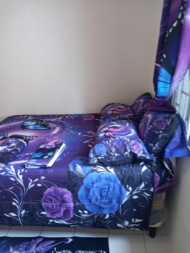 a purple couch with blue flowers on it at Holiday rooms in St Thomas Jamaica in Clifton