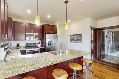 a kitchen with wooden cabinets and a counter top with stools at Blue River Condo Unit 203 in Silverthorne