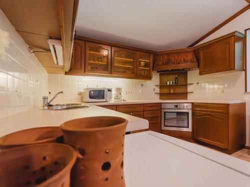 een keuken met houten kasten en een wit aanrecht bij Apartment Landhaus St- Georg-8 by Interhome in Bad Gastein