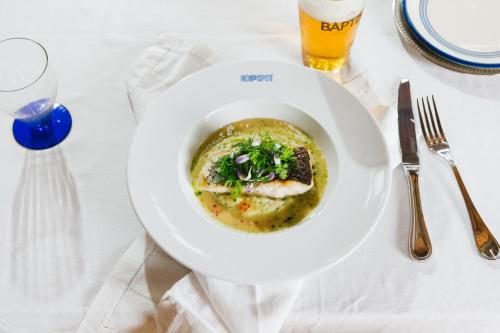 a plate of food on a table with a glass of beer at Hopspot in Evergem