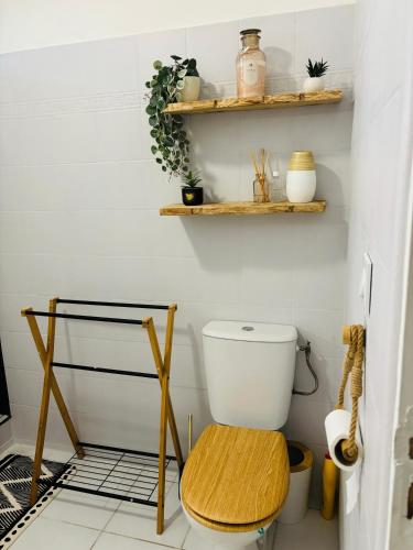 a bathroom with a toilet and shelves on the wall at La Canopé - T2 calme et central avec son jacuzzi in Rémire-Camp