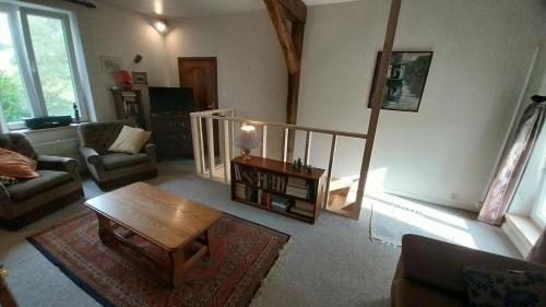 a living room with a couch and a coffee table at Fermette Ardennaise typique in Wanlin