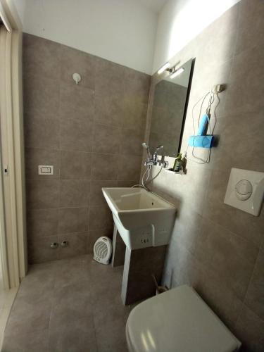 a bathroom with a sink and a toilet at Red House- Camera per quattro in Montecorvino Rovella