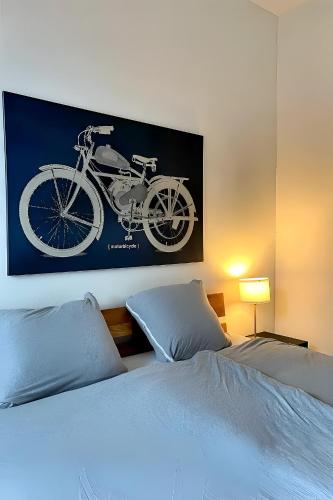 a picture of a bike hanging above a bed at Cocon by Stay Swiss - 1 bedroom apartments in old town in Porrentruy