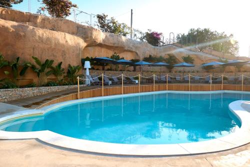 a large swimming pool with blue water at Villa Vittoria Hotel in Alcamo