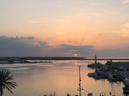 a sunset over a body of water with boats at Depandance sul porto in Molfetta