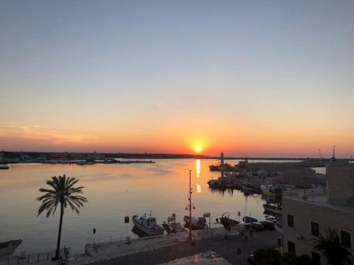 a sunset over a harbor with boats in the water at Depandance sul porto in Molfetta