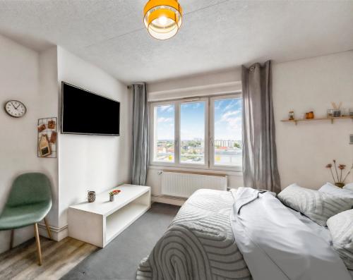 une chambre avec un lit, une télévision et une fenêtre dans l'établissement Confort et vue à deux pas du centre, à Reims