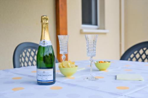 a bottle of champagne sitting on a table with chips at L'Ajuda Avec Piscine et Clim in Savignac-les-Églises