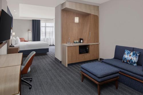a hotel room with a bed and a couch at Courtyard by Marriott San Angelo in San Angelo
