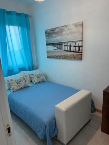 a bedroom with a bed with blue curtains and a pier at Appartamento La Pelosa in Stintino