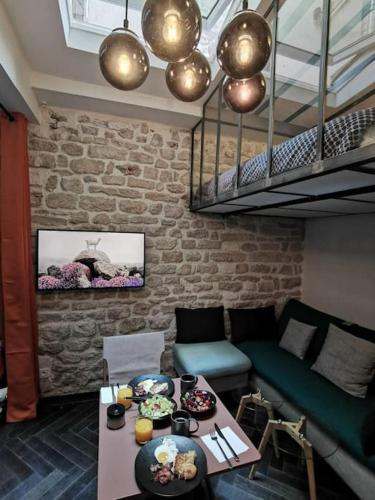 - un salon avec un canapé et une table avec de la nourriture dans l'établissement Le Petit Atelier Des Lumières, VÉRANDA AGRÉABLE, à Paris