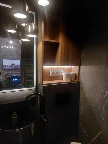 La salle de bains est pourvue d'un lavabo et d'un comptoir éclairé. dans l'établissement Le Petit Atelier Des Lumières, VÉRANDA AGRÉABLE, à Paris