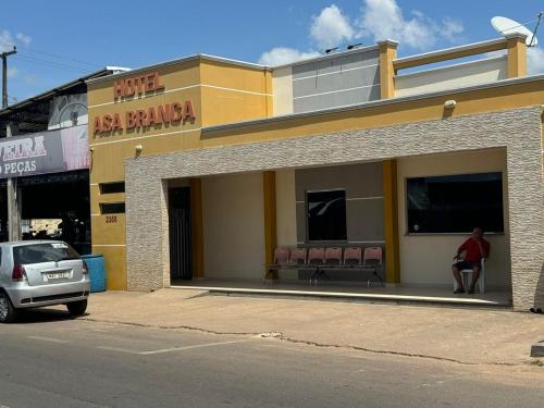 a man sitting in the window of a restaurant at Hotel Asa Branca in Boa Vista