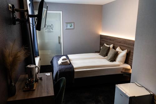 a hotel room with a bed and a table at Hotel Du Commerce in Oostburg