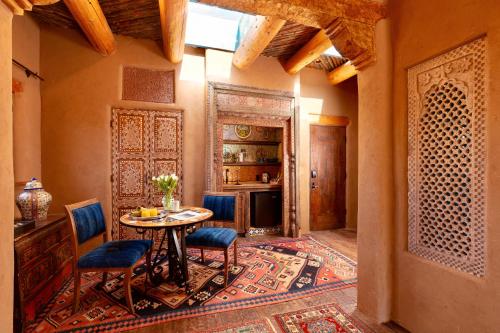 a dining room with a table and chairs on a rug at The Inn of Five Graces in Santa Fe