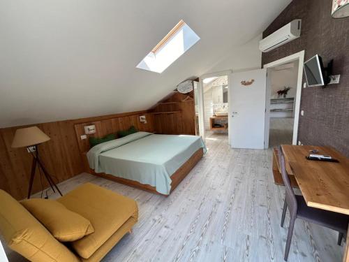 a bedroom with a bed and a couch and a table at B&B COL DE LE MOLE - DOLOMITI BELLUNESI in Belluno