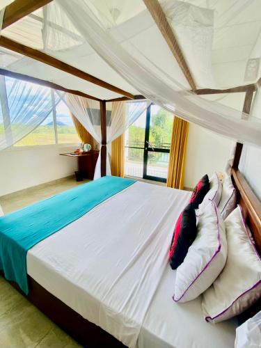 a bedroom with a bed with a canopy at Organic Garden Resort Sigiriya in Sigiriya