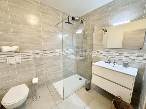 une salle de bain avec une douche, des toilettes et un lavabo dans l'établissement T2 moderne avec vue mer et proche centre-ville, à Propriano