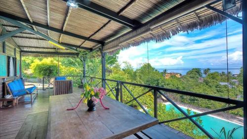 a balcony with a table and a view of the ocean at Luxury villa in Nosy Be with pool in Nosy Be