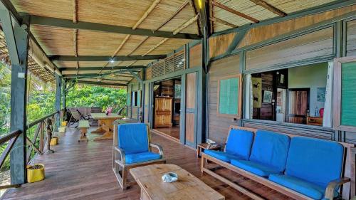 a porch of a house with blue chairs and a table at Luxury villa in Nosy Be with pool in Nosy Be