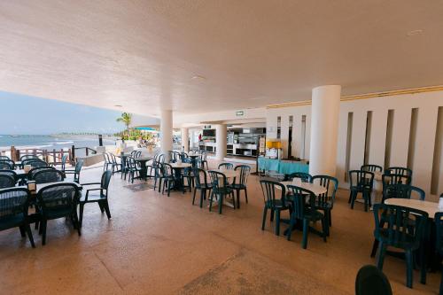 a restaurant with tables and chairs and the ocean at Azul Ixtapa All Inclusive Resort in Ixtapa