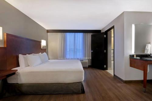 a bedroom with a large white bed and a desk at Hyatt Place San Antonio North Stone Oak in San Antonio