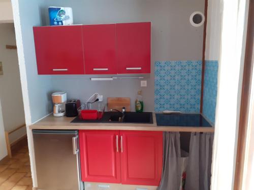 une cuisine avec des armoires rouges et un évier dans l'établissement Chalet Blanche neige, à Saint-Jean-de-Sixt